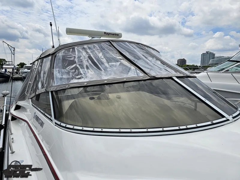Slide: The Image of 2006 Fountain 48 Express Cruiser with clear canopy, docked under cloudy skies. - 17