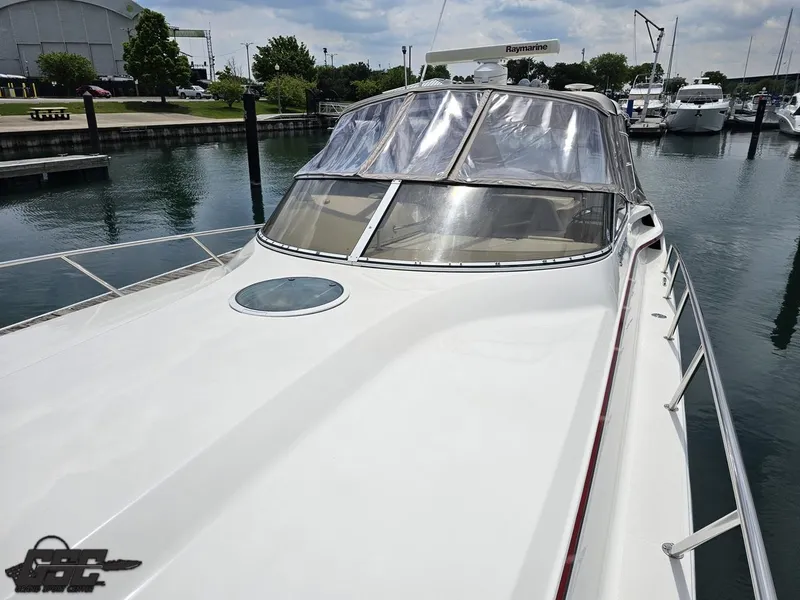 Slide: The Image of 2006 Fountain 48 Express Cruiser docked at marina, showcasing sleek design and clear canopy. - 22