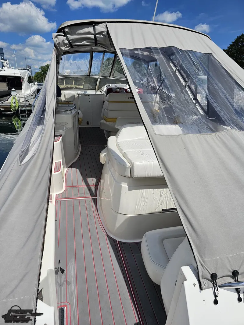 Slide: The Image of 2006 Fountain 48 Express Cruiser with covered seating area, docked under a clear blue sky. - 27