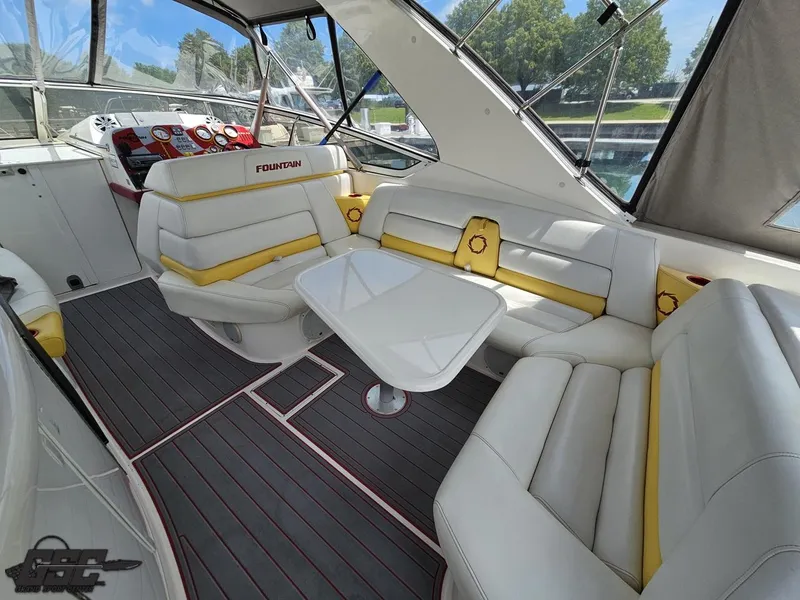 Slide: The Image of 2006 Fountain 48 Express Cruiser interior with white and yellow seating, table, and helm. - 33