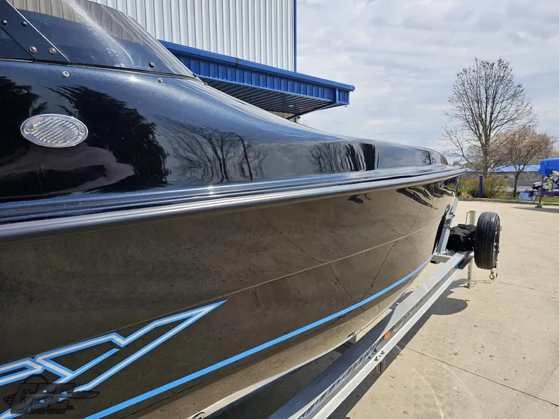 Slide: The Image of 2022 Velocity 290SC Signature Series boat on trailer, sleek black design, outdoor setting. - 13