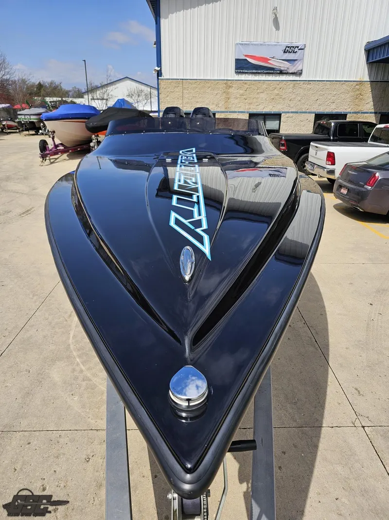 Slide: The Image of 2022 Velocity 290SC Signature Series boat, sleek black design, displayed outdoors. - 16