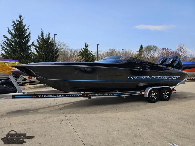 Slide: The Image of 2022 Velocity 290SC Signature Series boat on trailer, sleek black design, parked outdoors. - 20