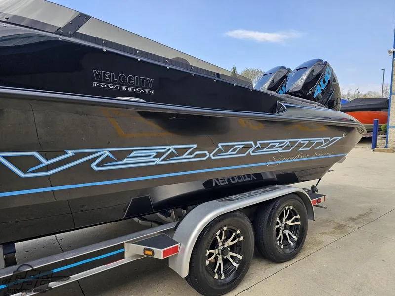 Slide: The Image of 2022 Velocity 290SC Signature Series powerboat on trailer, featuring sleek black design. - 22