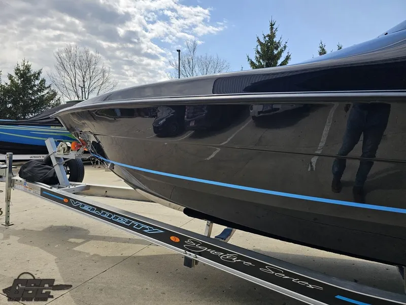 Slide: The Image of 2022 Velocity 290SC Signature Series boat on trailer, sleek black design, outdoor setting. - 23