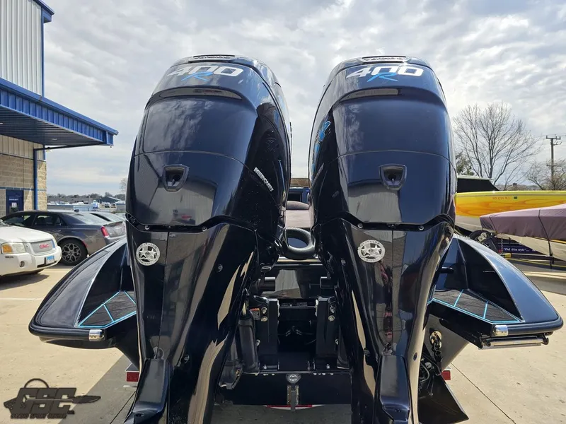 Slide: The Image of Twin outboard motors on a 2022 Velocity 290SC Signature Series boat, parked outdoors. - 32