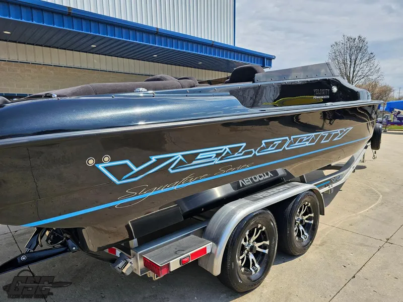 Slide: The Image of Velocity 290SC Signature Series 2022 boat on trailer, sleek design, parked outdoors. - 8