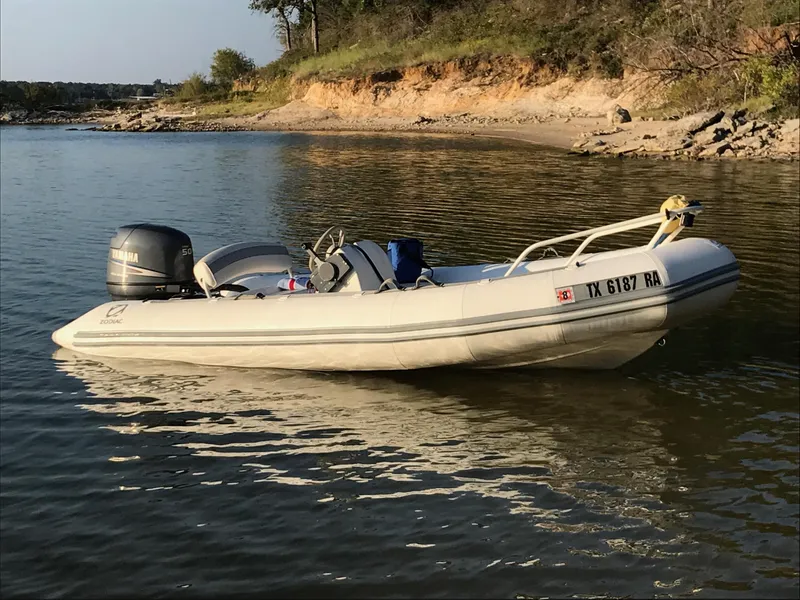 The Image of 2002 Zodiac Yachtline 420 Deluxe boat on a sandy shore with Yamaha engine. - 0