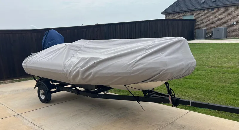 Slide: The Image of Covered Zodiac Yachtline 420 Deluxe boat on trailer, parked in driveway. - 11