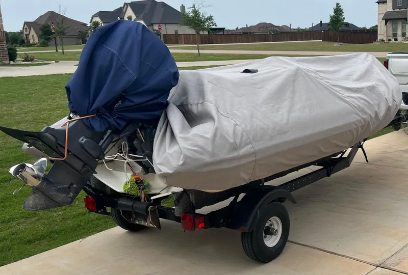 Slide: The Image of 2002 Zodiac Yachtline 420 Deluxe covered on trailer in suburban driveway. - 12