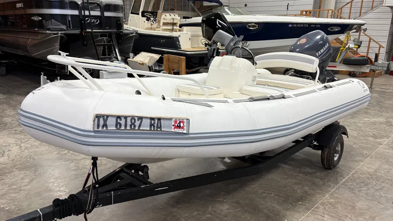 Slide: The Image of Zodiac Yachtline 420 Deluxe 2002 inflatable boat on trailer in storage facility. - 13