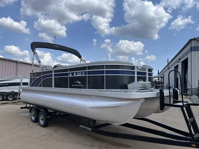 Slide: The Image of 2020 Bennington 22 SLX pontoon boat on trailer under blue sky. - 1