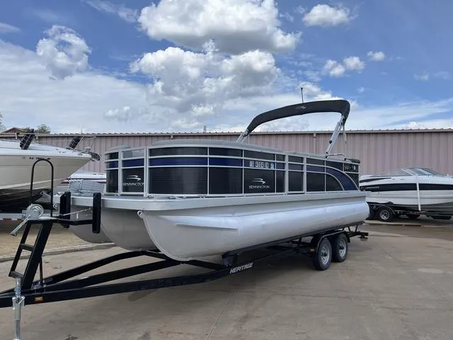 Slide: The Image of 2020 Bennington 22 SLX pontoon boat on trailer, parked outdoors under a cloudy sky. - 2
