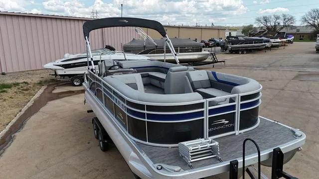 Slide: The Image of 2020 Bennington 22 SLX pontoon boat with canopy, parked on a trailer in a lot. - 3
