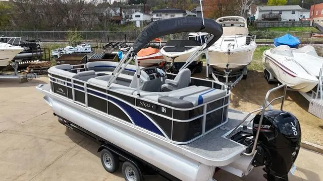 Slide: The Image of 2020 Bennington 22 SLX pontoon boat on trailer, featuring a Mercury outboard motor. - 5