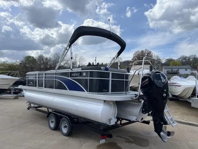 Slide: The Image of 2020 Bennington 22 SLX pontoon boat on trailer, under cloudy sky. - 6