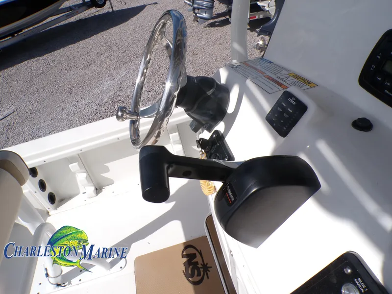 Slide: The Image of 2023 NauticStar 227 XTS boat console with steering wheel and throttle controls. - 12