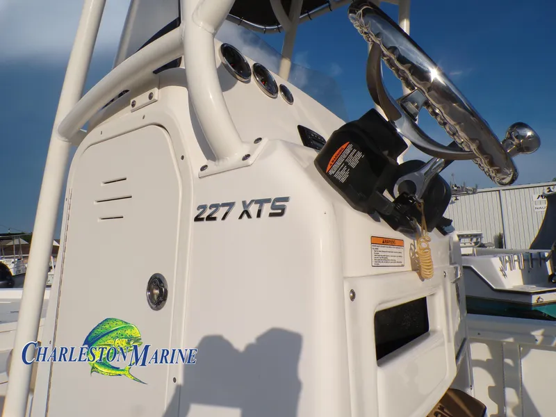 Slide: The Image of 2023 NauticStar 227 XTS boat console with steering wheel, Charleston Marine logo visible. - 13