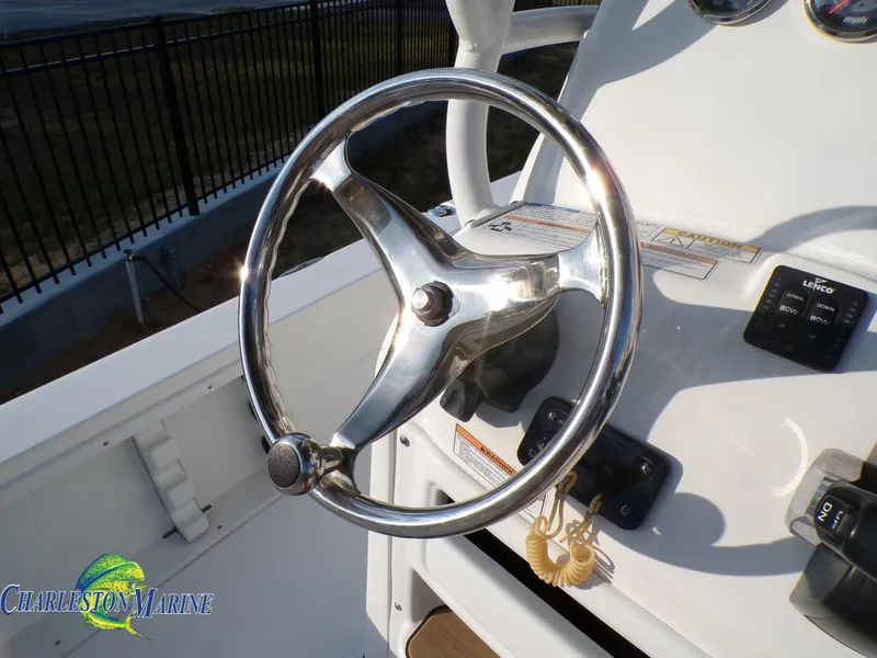 Slide: The Image of 2023 NauticStar 227 XTS boat steering wheel and dashboard controls. - 16