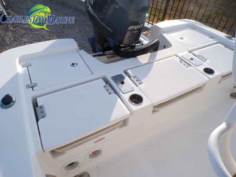 Slide: The Image of 2023 NauticStar 227 XTS boat deck with storage compartments and motor. - 19