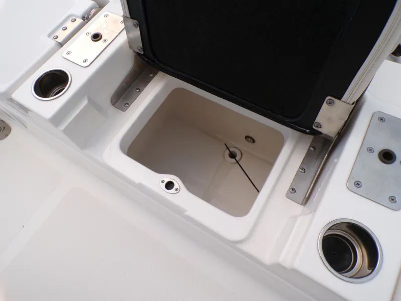 Slide: The Image of 2023 NauticStar 227 XTS boat storage compartment with cup holders and metal fittings. - 28