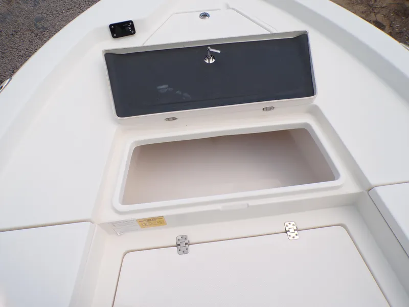 Slide: The Image of 2023 NauticStar 227 XTS boat storage compartment with open hatch and latch. - 32
