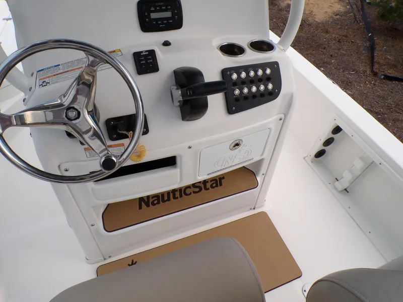 Slide: The Image of 2023 NauticStar 227 XTS boat console with steering wheel and controls. - 33