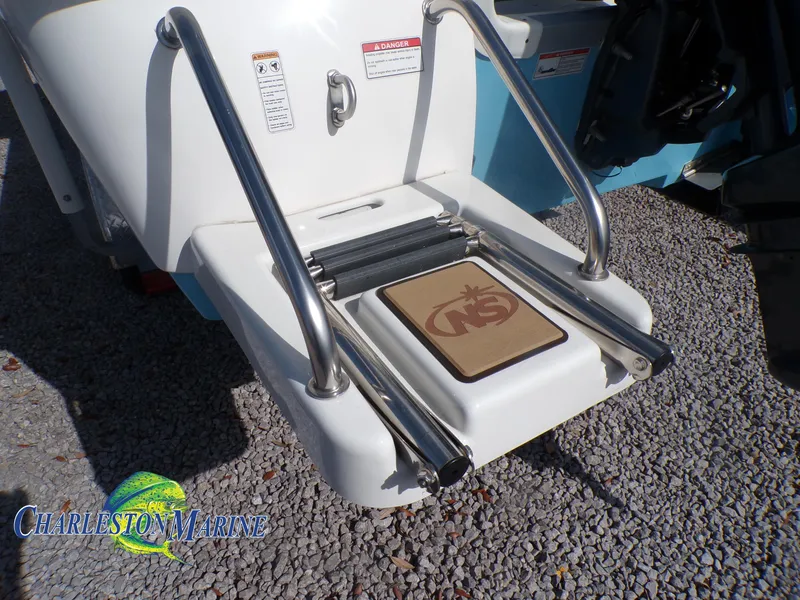 Slide: The Image of 2023 NauticStar 227 XTS boat ladder on gravel, featuring Charleston Marine logo. - 8