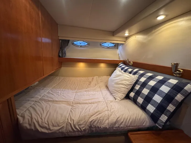 Slide: The Image of Cozy bedroom in 2004 Meridian 490 Pilothouse yacht with wood cabinets and porthole windows. - 18