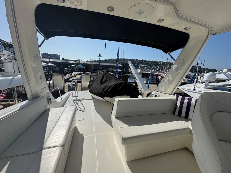 Slide: The Image of 2004 Meridian 490 Pilothouse yacht interior with seating, docked at marina under sunny sky. - 3
