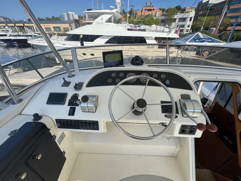 Slide: The Image of 2004 Meridian 490 Pilothouse helm with steering wheel and controls at marina. - 4