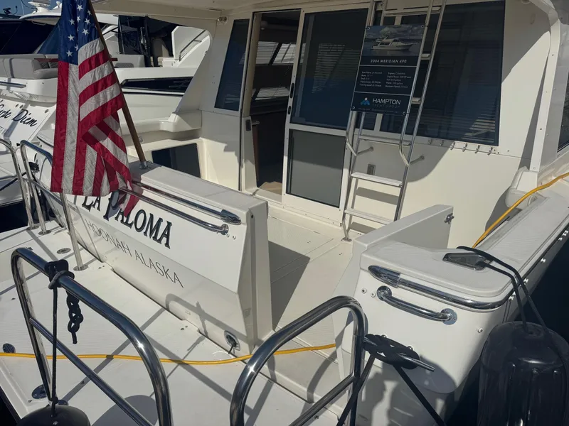 Slide: The Image of 2004 Meridian 490 Pilothouse yacht with American flag, docked, rear view. - 6