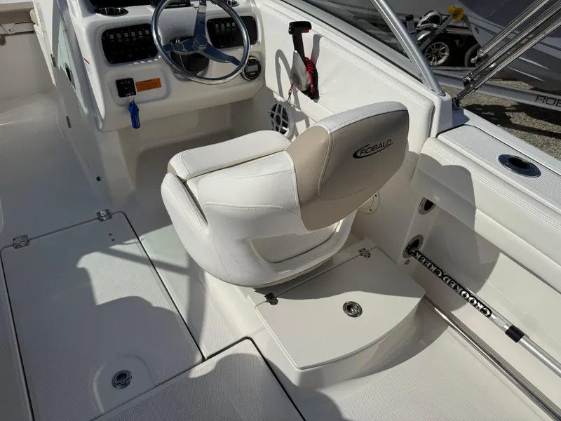 Slide: The Image of 2024 Robalo R207 Dual Console boat interior with white seating and steering wheel. - 20