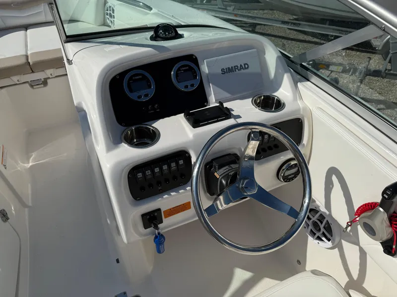 Slide: The Image of 2024 Robalo R207 Dual Console boat dashboard with steering wheel and Simrad display. - 24