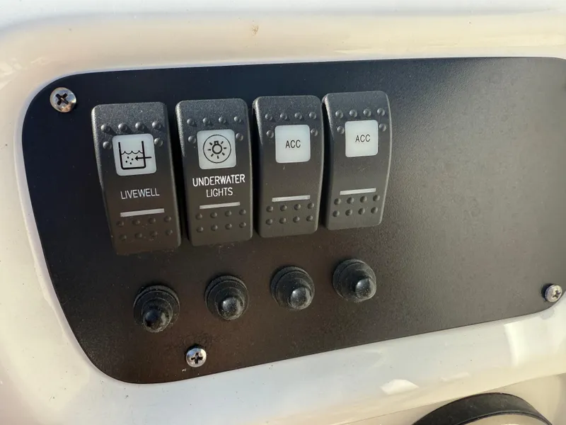 Slide: The Image of Control panel of 2024 Robalo R207 Dual Console with switches for livewell and underwater lights. - 28