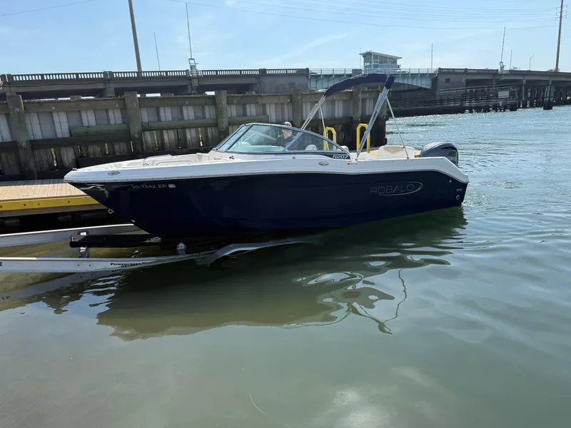 Slide: The Image of 2024 Robalo R207 Dual Console boat docked in calm waters. - 32