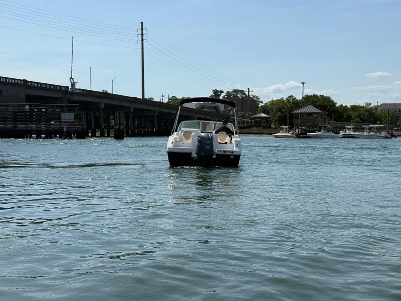 Slide: The Image of 2024 Robalo R207 Dual Console boat cruising on a sunny day near a bridge. - 40