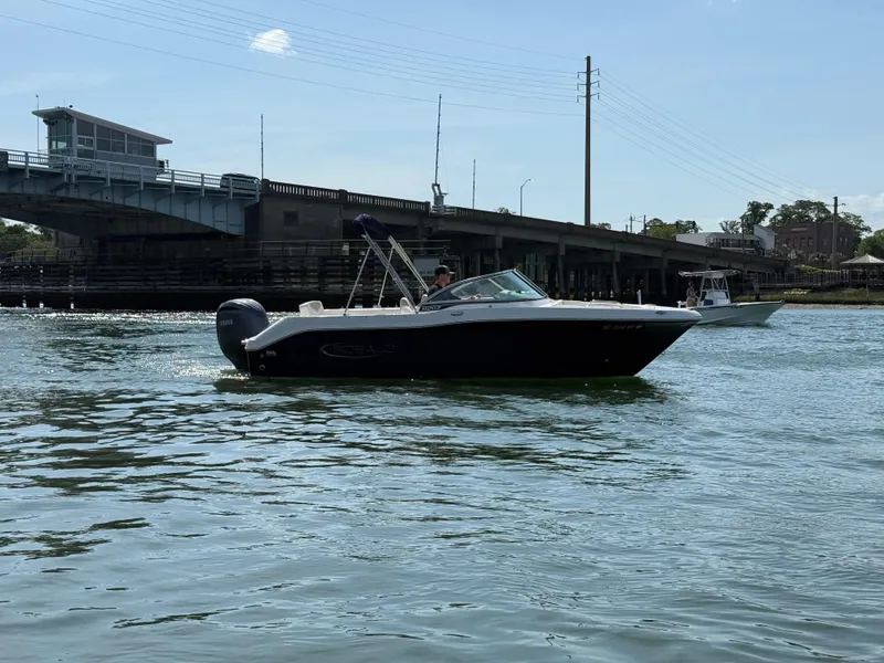 Slide: The Image of 2024 Robalo R207 Dual Console boat on water near a bridge. - 42