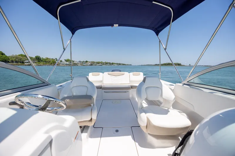 Slide: The Image of 2024 Robalo R207 Dual Console boat interior with seating and canopy on a sunny day. - 53