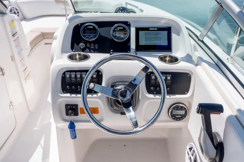 Slide: The Image of 2024 Robalo R207 Dual Console boat dashboard with steering wheel and control panel. - 56