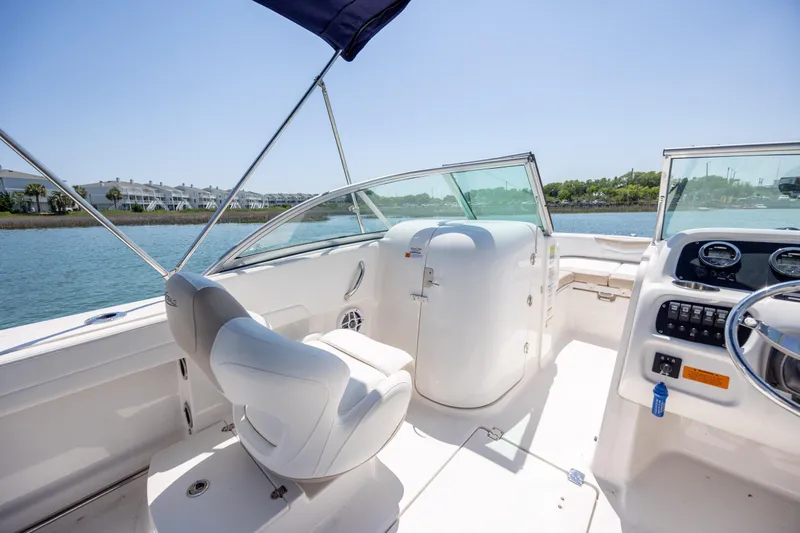 Slide: The Image of 2024 Robalo R207 Dual Console boat interior with helm, seating, and water view. - 58