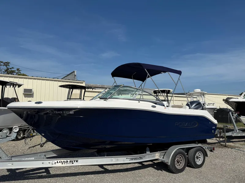 Slide: The Image of 2024 Robalo R207 Dual Console boat on trailer, blue hull, sunny day. - 8