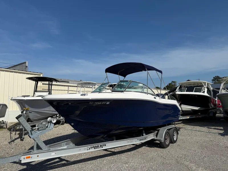 Slide: The Image of 2024 Robalo R207 Dual Console boat on trailer under clear blue sky. - 9