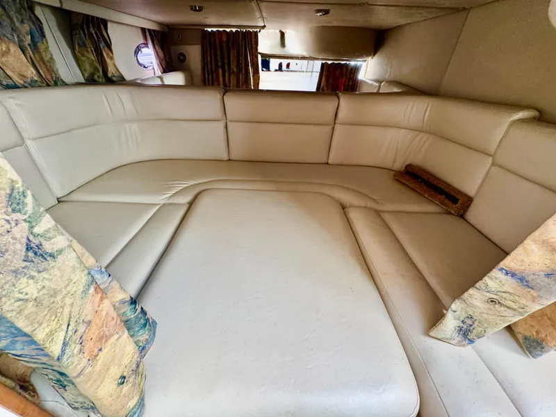 Slide: The Image of 1999 Chaparral 290 Signature Cruiser interior with beige seating and patterned curtains. - 15