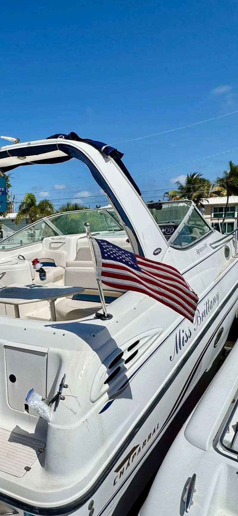 Slide: The Image of Chaparral 290 Signature Cruiser 1999 with American flag, docked under clear blue sky. - 18
