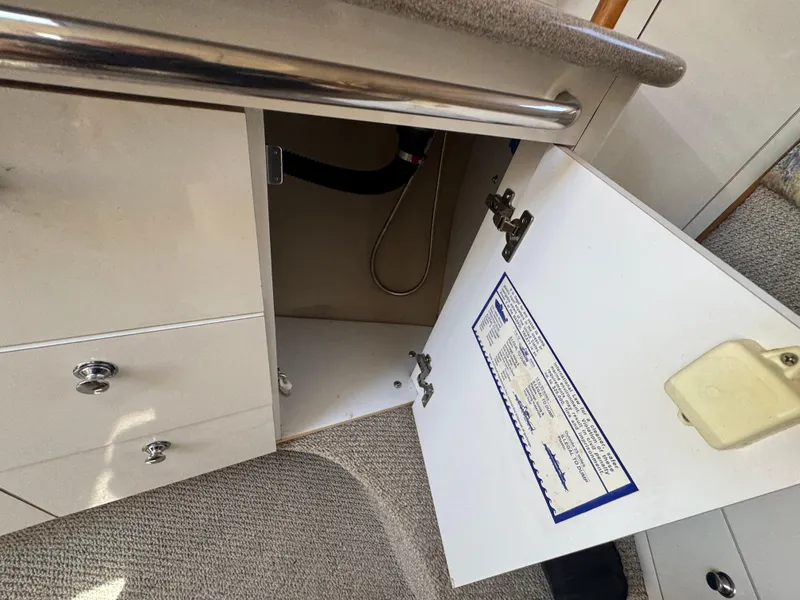 Slide: The Image of 1999 Chaparral 290 Signature Cruiser interior cabinet with open door and visible storage space. - 26