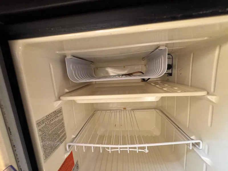 Slide: The Image of Interior of a refrigerator in a 1999 Chaparral 290 Signature Cruiser. - 28