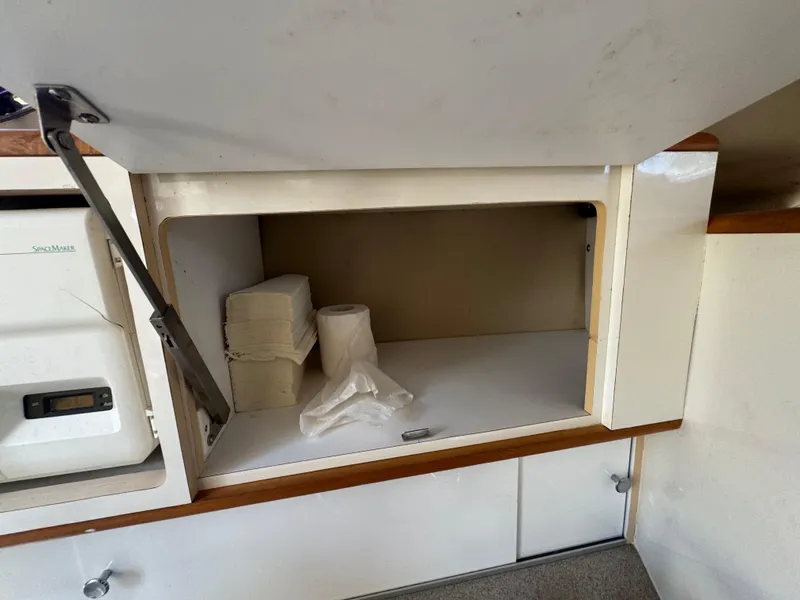 Slide: The Image of Cabinet storage in 1999 Chaparral 290 Signature Cruiser with paper towels and napkins. - 31