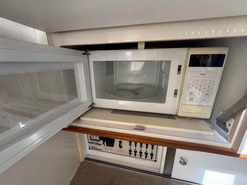 Slide: The Image of Microwave inside 1999 Chaparral 290 Signature Cruiser's compact kitchen area. - 33
