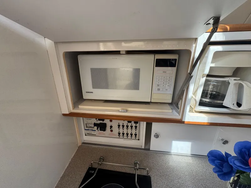 Slide: The Image of 1999 Chaparral 290 Signature Cruiser kitchen with microwave and control panel. - 34